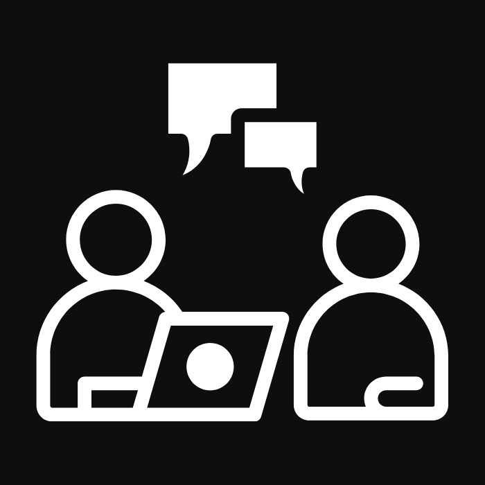 Two people having a collaborative discussion with a laptop and chat bubbles, representing client consultation and teamwork.